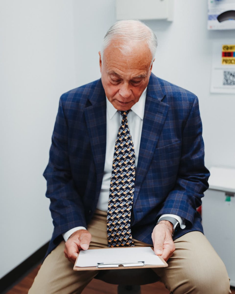 Dr. Kenneth Jaffe, OrthoSports orthopedic oncologist, reviewing a clipboard in an exam room