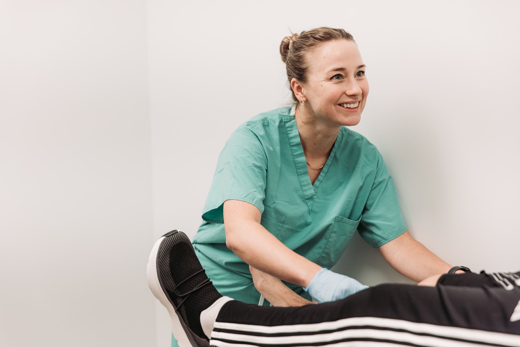 An OrthoSports clinician working with a patient's leg